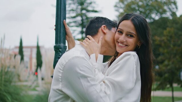 Romantic pair bonding at park close up. Passionate man kissing girlfriend neck