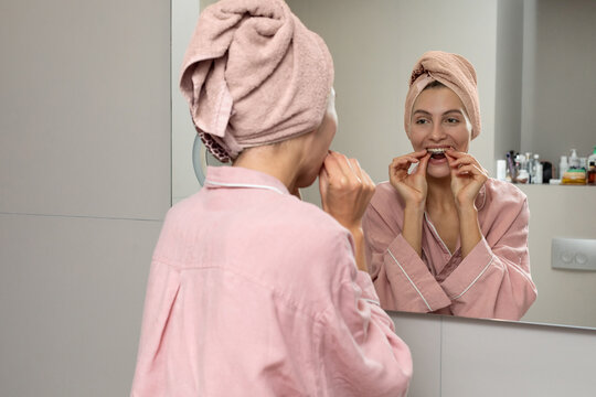 Woman brushing teeth in bathroom