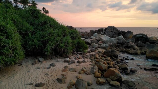 Drone view of an island beach with coconut trees and ocean waves
