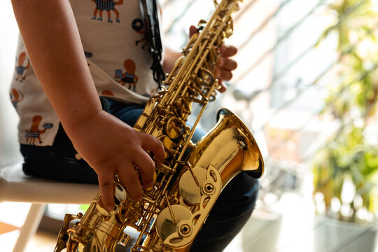 faceless kid playing saxophone