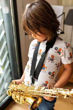 young boy holding his saxophone