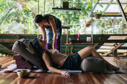 Yoga teacher practicing restorative yoga with singing bowls