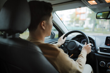 Man's hand on the steering wheel of a car