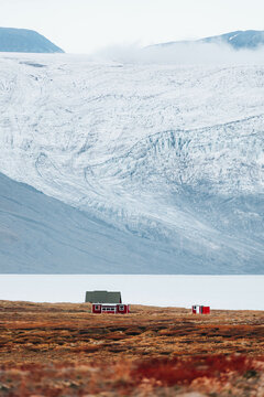 Lonely house in mountain on glacier background 