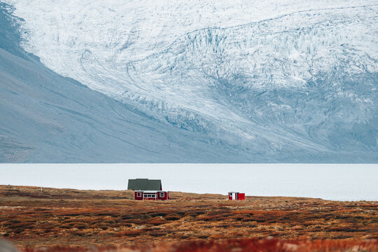 Lonely house in mountain on glacier background 