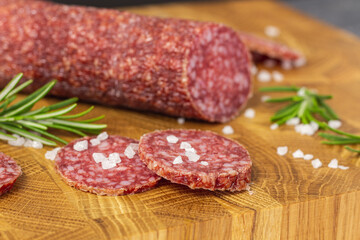 Sausage on a wooden board. Sausage with raspberry and salt. Sausage on top. Macro Sausage