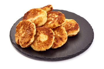 Cottage cheese pancakes, syrniki, ricotta fritters on stone plate, isolated on white background. High resolution image.