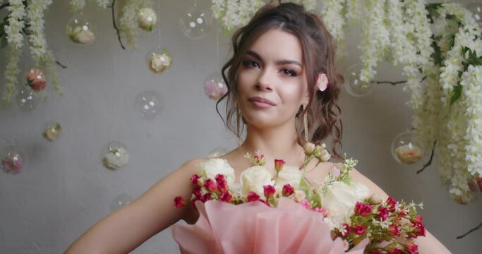 A floral-inspired photoshoot takes place in a vibrant studio, featuring a model showcasing a stunning bouquet for advertising purposes in the springtime