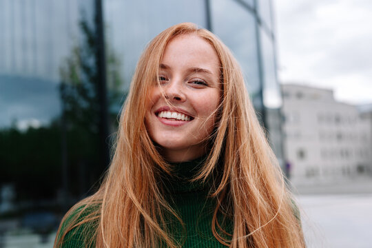 Smiling woman with long hair looking at camera