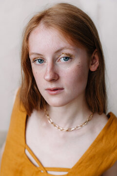 Charming ginger young woman with golden necklace in evening dress