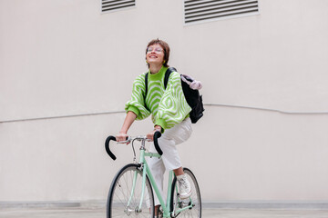 Cheerful woman riding bicycle on street