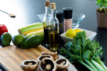 Close up of vegetables, seasoning and olive oil and balsamic vinegar on countertop in kitchen
