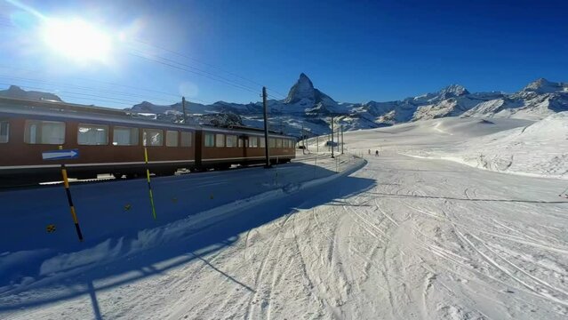 The train from Gornegrat riding along the skiers in Zermatt ski region.