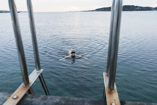 Yung woman taking a cold bath in the ocean
