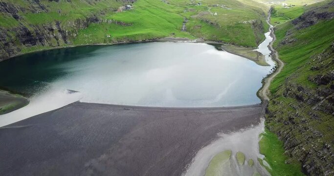 Slow drone shot  of a salt water pond near Saksun, small, isolated village surrounded by mountains on Faroe islands
