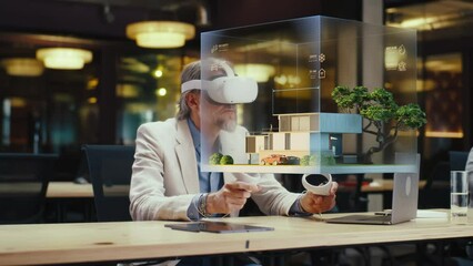 Male designer uses VR headset and wireless controllers, makes architectural project, creates house exterior design in virtual reality. Modern hi-tech company. 3D hologram. Future digital technologies. - Powered by Adobe