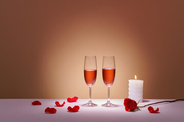 Two glasses of rose wine and red grapes on a colored background.