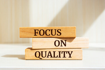 Wooden blocks with words 'Focus On Quality'.