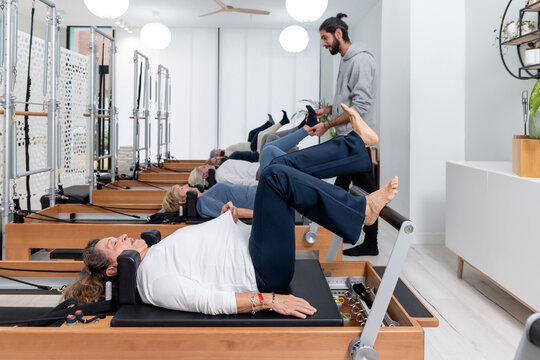 Instructor helping with exercise on Pilates reformer