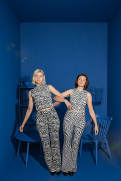 Conceptual portrait with two fashionable girls supporting each other