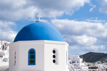 Fototapeta na wymiar View of white houses and greek church with blue dome in Oia, Santorini
