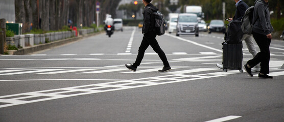 街の横断歩道を渡るビジネスマンの姿