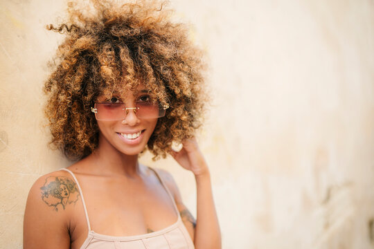Cuban female touching hair and smiling for camera