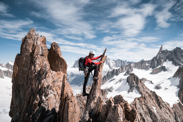 Mountaineer climbing a narrow rock ridge in the Mont Blanc massif in the Alps.