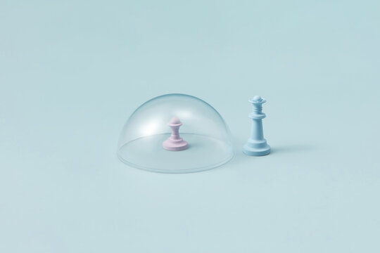 Pink pawn under glass dome with blue chess queen.