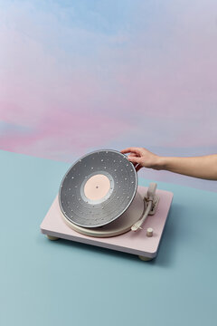 Female hand hold vinyl plate with pearls pattern.