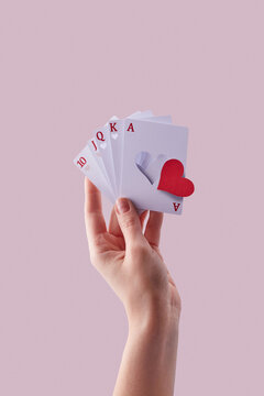 Cards with cut red falling paper heart in hand.