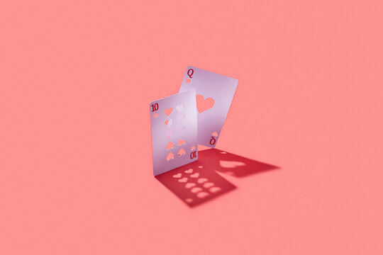 Queen and ten cards with cut heart pattern.