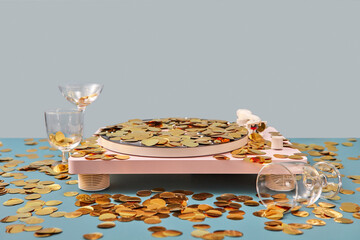 Record player covered with gold confetti.