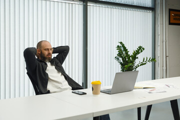Male employee watching video on laptop in office
