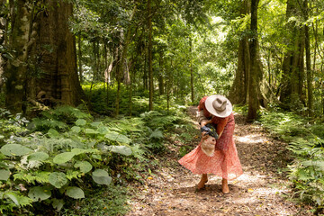woman playfully tips son upside down on a walk