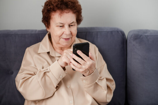 Happy retired woman scrolls on her phone