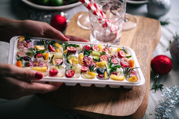 Holding frozen fruit filled ice cube tray