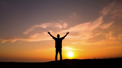 Fototapeta premium Silhouette of man raised hands at sunset background, wide angle