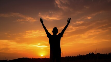 Fototapeta premium Silhouette of man raised hands at sunset background, V-shape pose