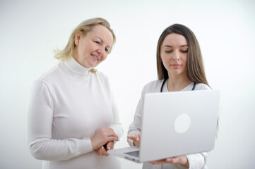 Adult doctor and young nurse with laptop on white backgrund,. High quality photo