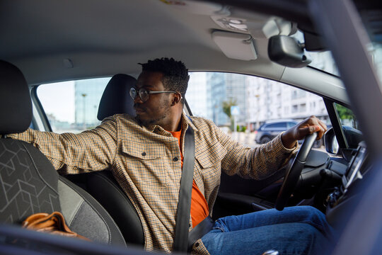 Driver looking out behind car to reverse