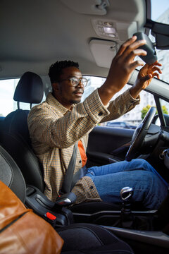 Student adjusts rearview mirror in car