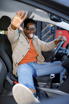 New car owner posing silly in car