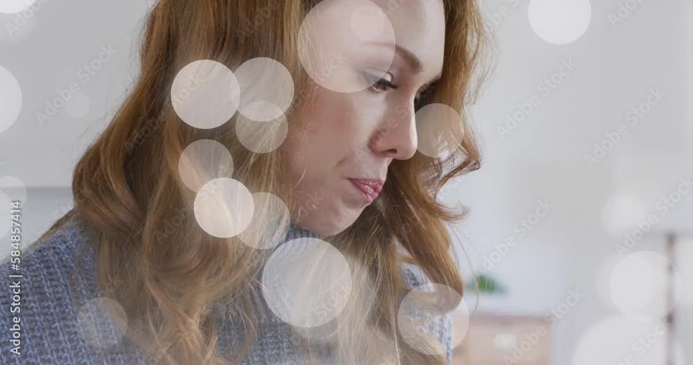 Canvas Prints Animation of light spots over caucasian woman drinking coffee in kitchen