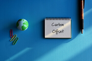 There is a notebook with the word Carbon Offset. It is eye-catching image.
