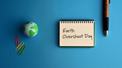 There is a notebook with the word Earth Overshoot Day. It is eye-catching image.