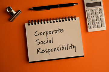 There is a notebook with the word Corporate Social Responsibility. It is eye-catching image.
