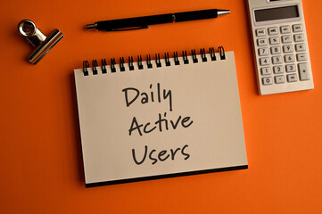 There is a notebook with the word Daily Active Users. It is eye-catching image.