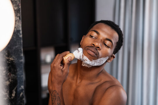 Man Applying Shaving Foam On His Face With A Brush - Powered by Adobe