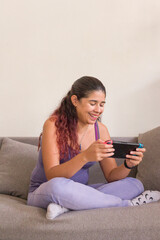 Obraz na płótnie Canvas Latin woman playing happy game portable console. generation z gamer with controller. venezuelan mid